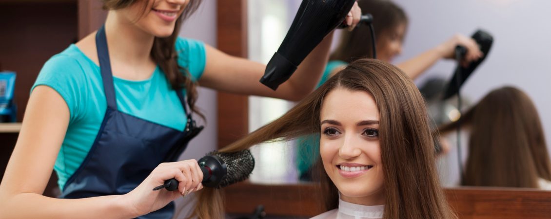 female-hairdresser-using-hairbrush-and-hair-dryer